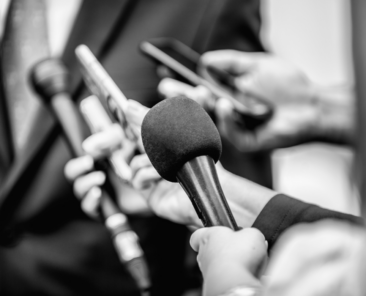 Periodistas sosteniendo micrófonos en una entrevista